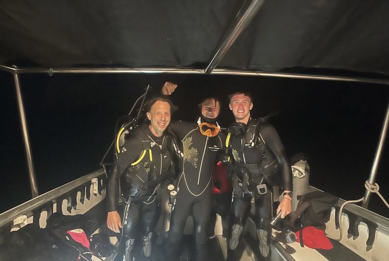 Max Gallinek and two dive buddies on a boat after a night dive