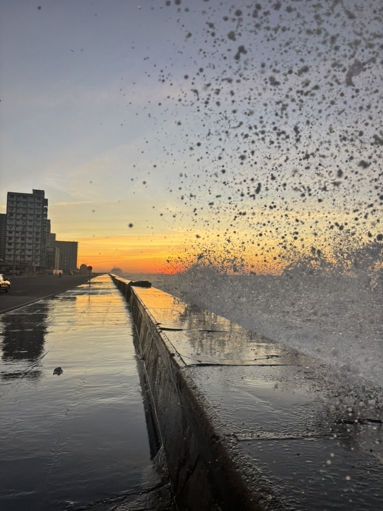 Waves breaking over the Malecón seawall in Havana at sunrise